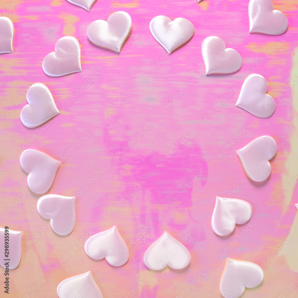 Fototapeta premium Beautiful silk pink hearts on a holographic pink background. Holiday concept Valentine Day. Plase for text . Flat lay.