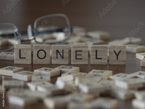 The concept of Lonely represented by wooden letter tiles photo