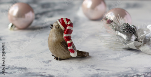 Fototapeta Naklejka Na Ścianę i Meble -  Little winter bird toy in Santa hat on marble background, Christmas composition