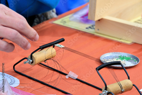 Fotografie, Obraz Creating a beaded strip using a small beading loom.