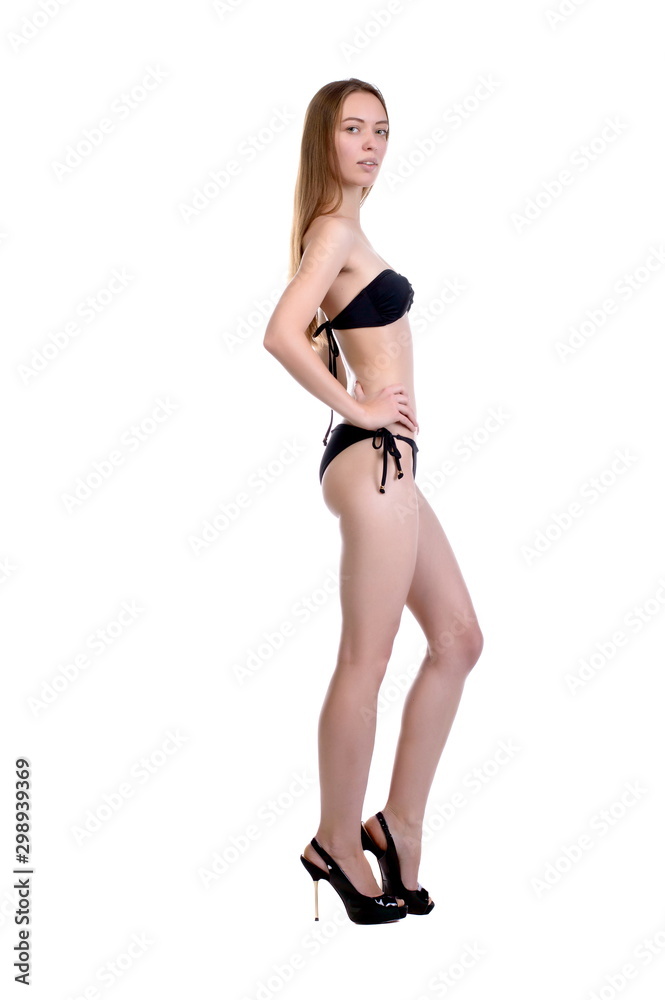 Model tests. Beautiful sexy girl with long hair in a black swimsuit, posing on a white background, in isolation