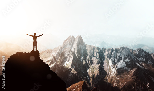 Bergsteiger erlebt absolutes Gipfelglück hoch über den Bergen photo