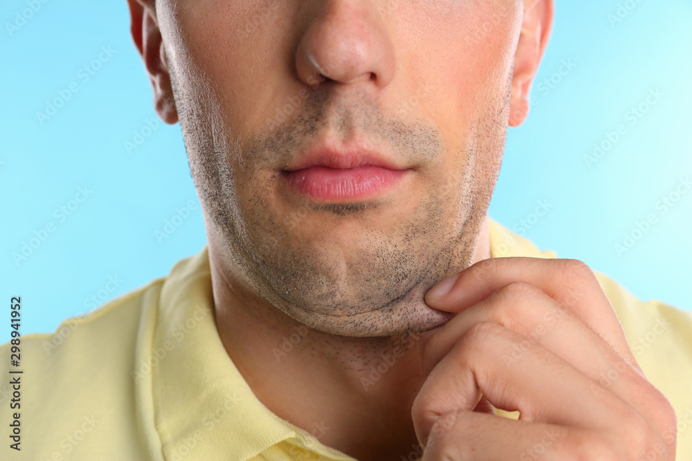 Fototapeta premium Young man with double chin on blue background, closeup