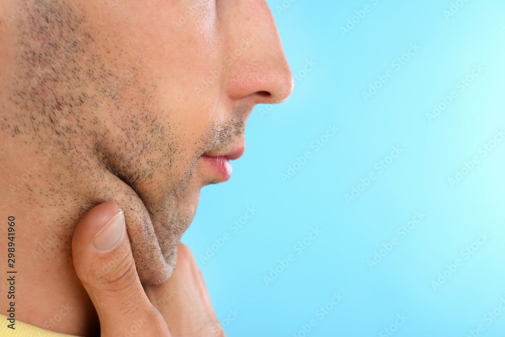 Naklejka premium Young man with double chin on blue background, closeup. Space for text