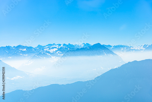 Majestic unique misty blue alpine skyline aerial view panorama of iced Swiss Alps and blue sky, taken from inside a cable lift cabin at mount Rigi Switzerland.