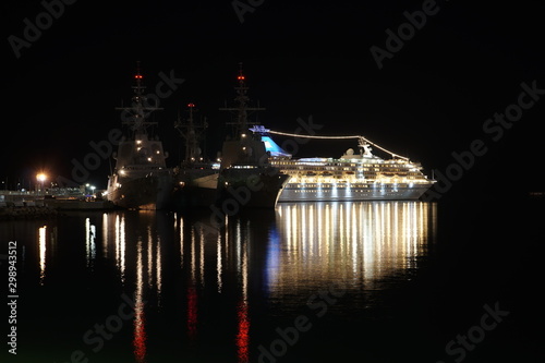 vista nocturna con sus reflejos de fragatas de la armada española almirante juan de bonbon, reina sofia y alvaro de bazan atracadas en puerto de malaga y crucero de pasajeros iluminado  photo