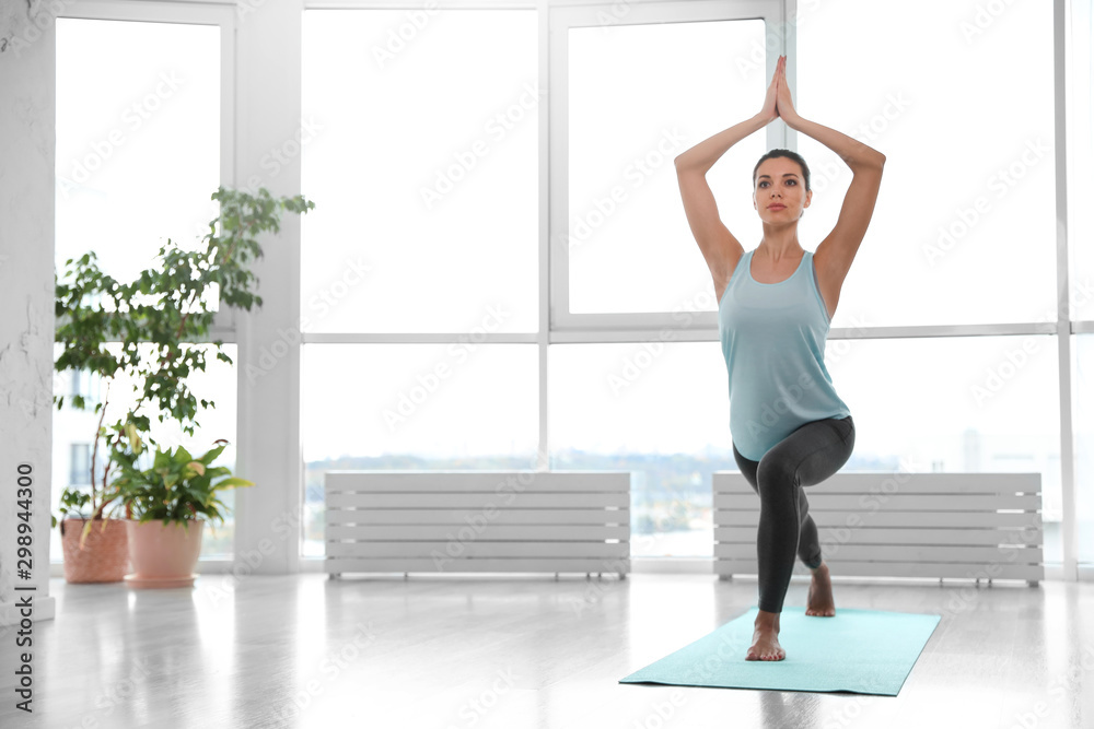 Young woman practicing crescent asana in yoga studio. High lunge pose