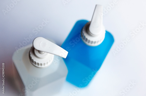 a white and a blue pump bottle with soap and hand spirit