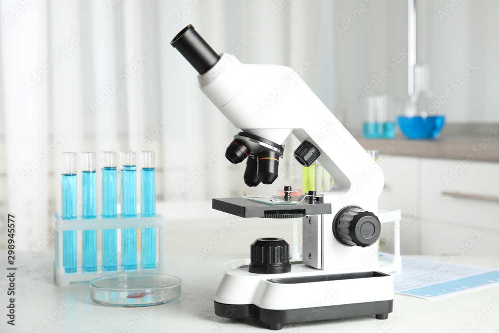 Modern microscope on white table in laboratory. Medical object Modern microscope on white table in laboratory. Medical object