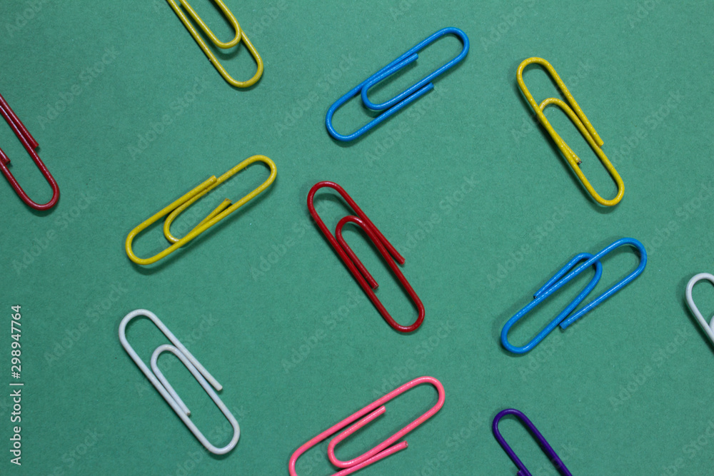 Colourful paperclips on a green colour background Colourful paperclips on a green colour background