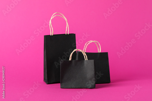 Small paper bags on pink background, space for text