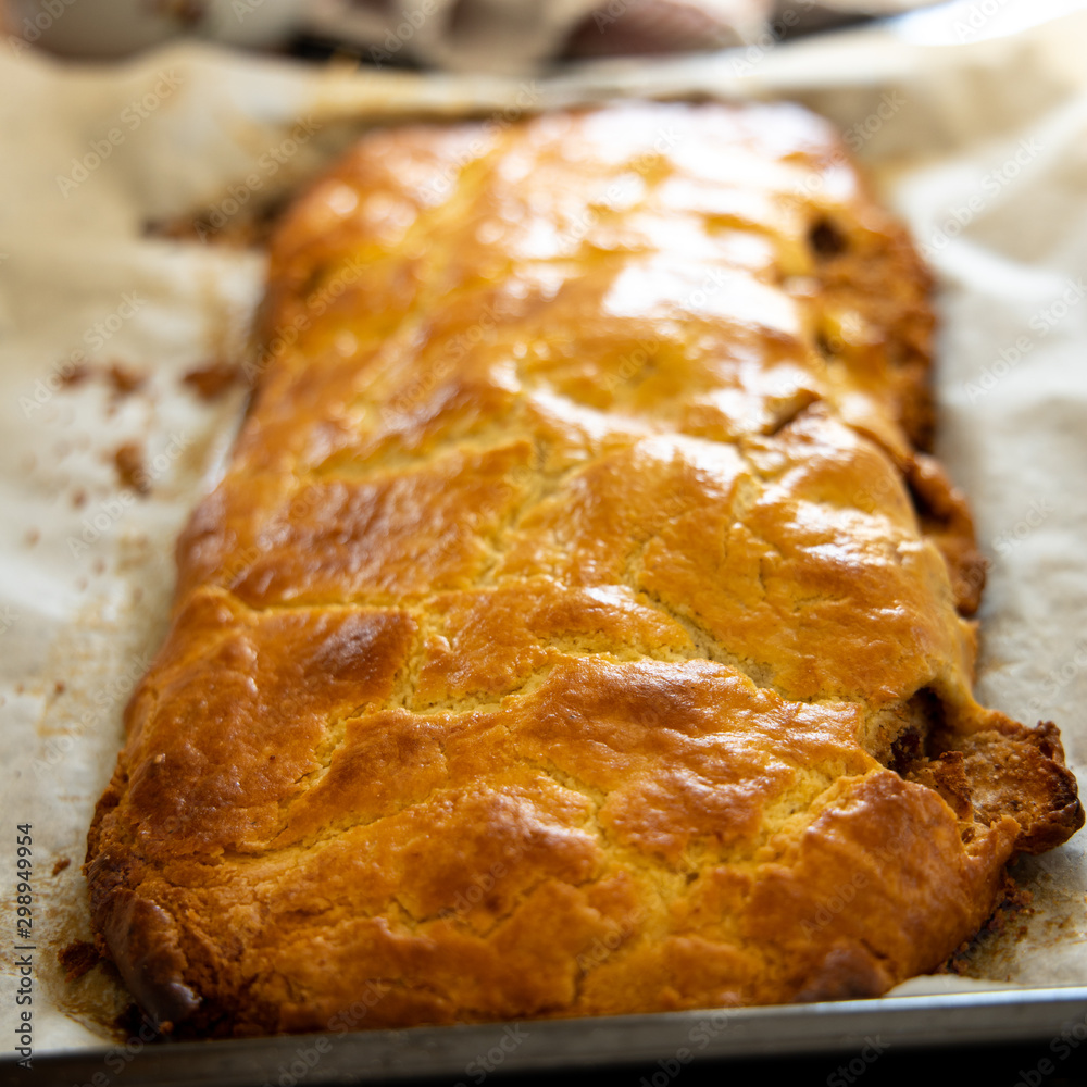 Fresh apple strudel by a recipe from South-Tirol lying on a baking tin