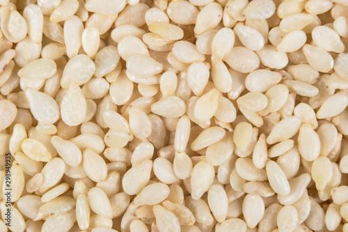 Macro shot of a raw white sesame seed background. Top view. Food Background. A scattering of sesame seeds. Healthy food. Natural food.