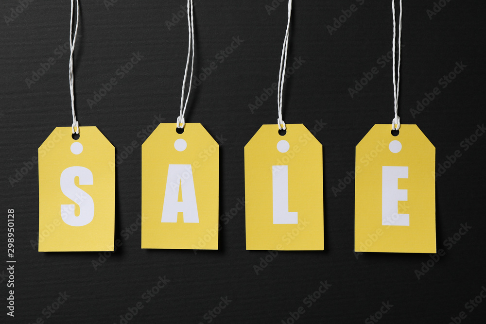 Inscription Sale on price tags on black background. Black Friday concept