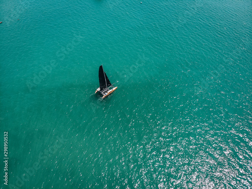 Bird eye view of the small sailing kayak; black sails in the wind. Regatta concept.