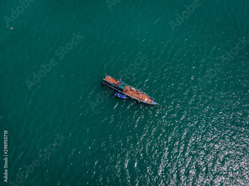 Drone view of the big old blue motorboat with huge empty deck in blue sea, violet lifeboat at its side  vessels concept. © Semachkovsky 
