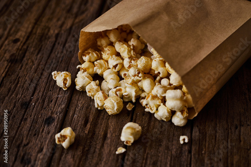 Delicious popcorn with caramel on wooden background..