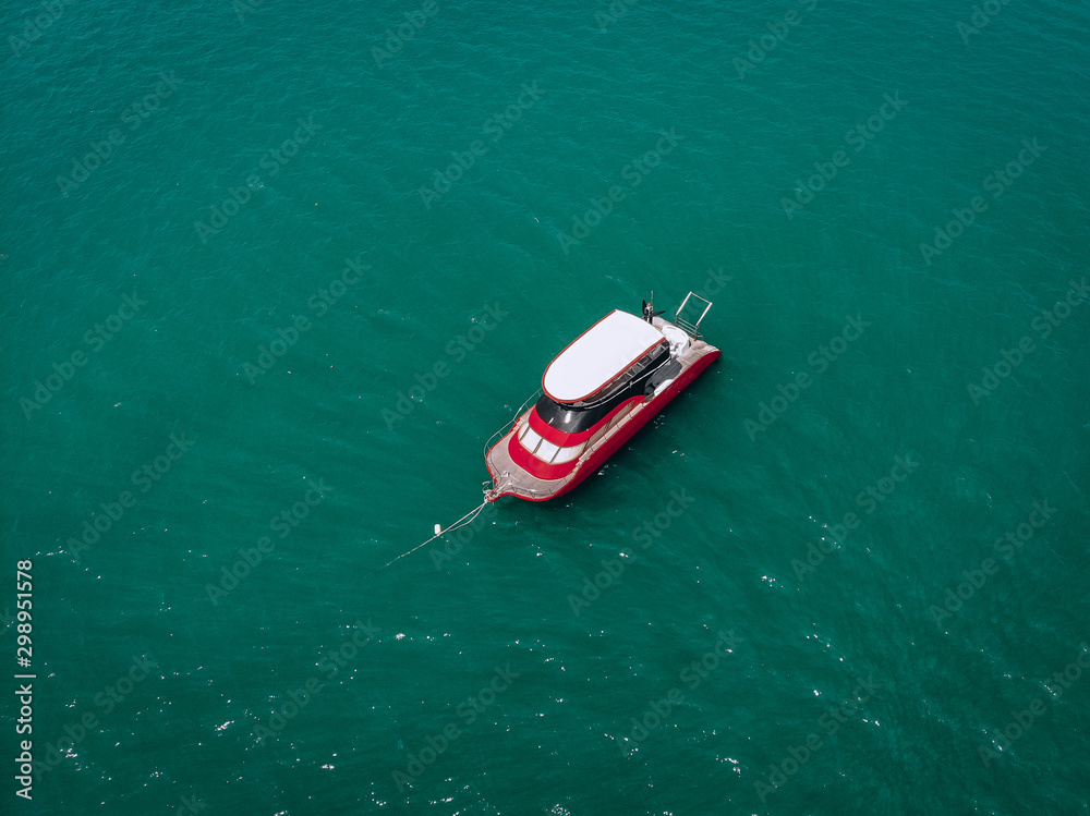 Drone view of the small brand-new red and white motorboat in blue sea, it shines in the bright sun; vessels concept. Drone view of the small brand-new red and white motorboat in blue sea, it shines in the bright sun; vessels concept.
