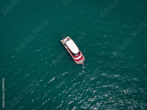 Drone view of the small brand-new red and white motorboat in blue sea, it shines in the bright sun  vessels concept. © Semachkovsky 