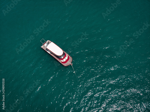 Drone view of the small brand-new red and white motorboat in blue sea, it shines in the bright sun  vessels concept. © Semachkovsky 