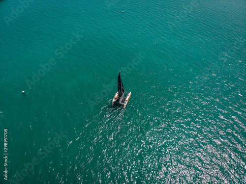 Bird eye view of the small sailing kayak; black sails in the wind. Regatta concept.