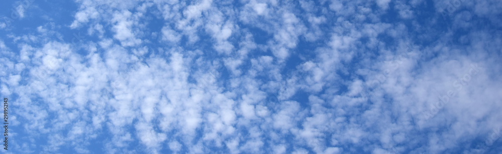 Weiße Schäfchenwolken vor blauen Himmel - Hintergrund