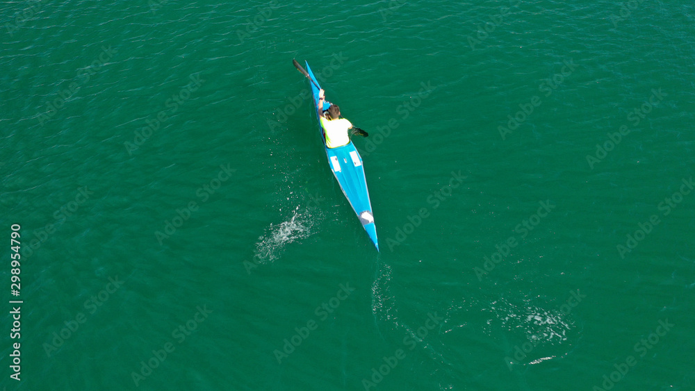 Aerial drone photo of man operating sport canoe in tropical exotic green lake
