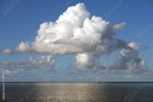 Weiße Wolke vor blauem Himmel im Wattenmeer an der Nordsee vor Hooksiel - Stockfoto
