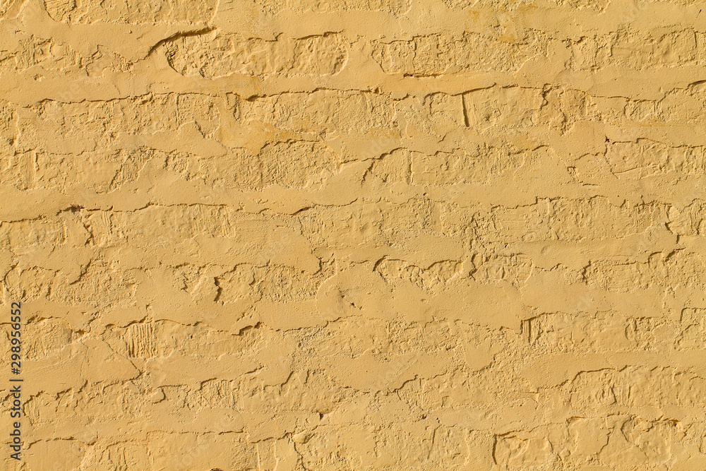 The brick wall is painted with yellow paint. Background.