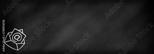 An envelope with a letter at an at sign on a letter drawn on a blackboard
