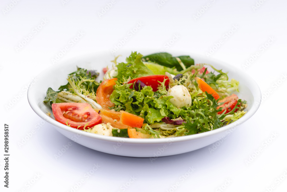 white deep plates with fresh salad ingredients mixed with sauce placed on isolated white background. A place for a menu, banner or advertisement white deep plates with fresh salad ingredients mixed with sauce placed on isolated white background. A place for a menu, banner or advertisement