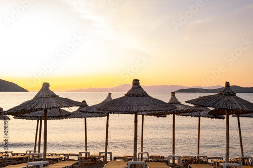 Beach umbrella in the Greece, landscape with beautiful sunrise and summer beach