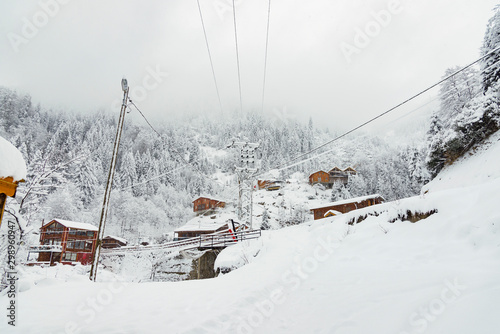 Wooden chalets under blizzard. © ardasavasciogullari