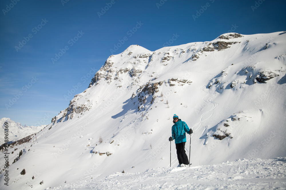 A skier on slope in alpine ski resort