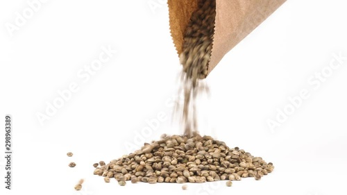 Close-up of hemp or cannabis seeds spilling out of brown eco paper pack. Natural painkiller concept. Isolated, on white background