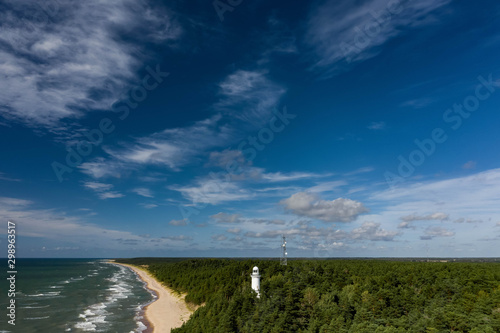 White Uzhava lighthouse on the shore of Baltic Sea. Sunny day.