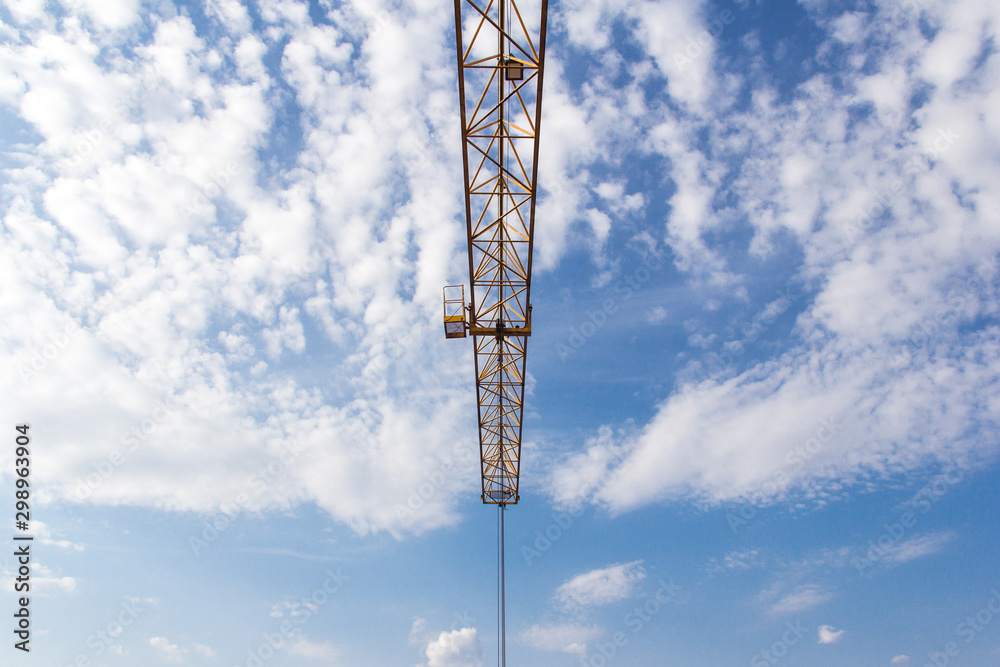 Boom tower crane against the blue sky.