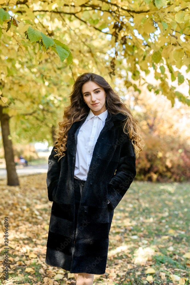 Beautiful young woman in a fur coat in the magical autumn forest. Beautiful young woman in a fur coat in the magical autumn forest.