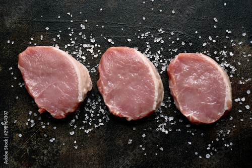 Slices of raw organic pork meat with ingredient for making. Top view with copy space.