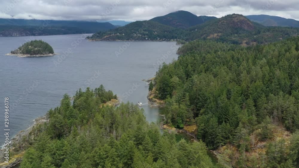 Aerial view over inlet, ocean and island with boat and mountains in beautiful British Columbia. Canada. 4K. Aerial view over inlet, ocean and island with boat and mountains in beautiful British Columbia. Canada. 4K.