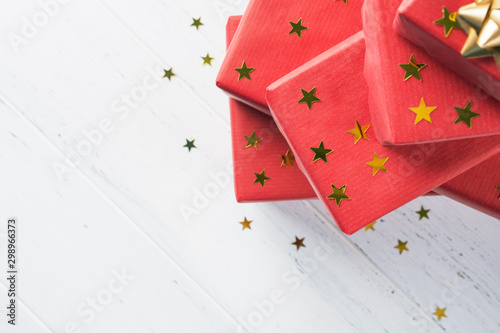 Part of stack with holiday red gift boxes with golden stars decoration
