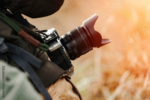 Billede på lærred Man photographer holding camera with long lens in outdoors during sunny autumn day