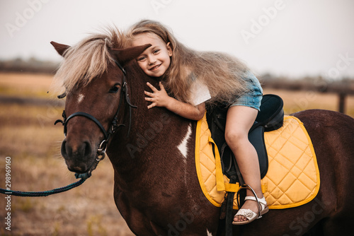 Εκτύπωση καμβά Adorable little girl riding a pony at summer