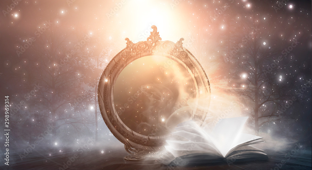 An open book and a magic mirror against the backdrop of a night landscape. Abstract dark scene, mystical background, fantasy.