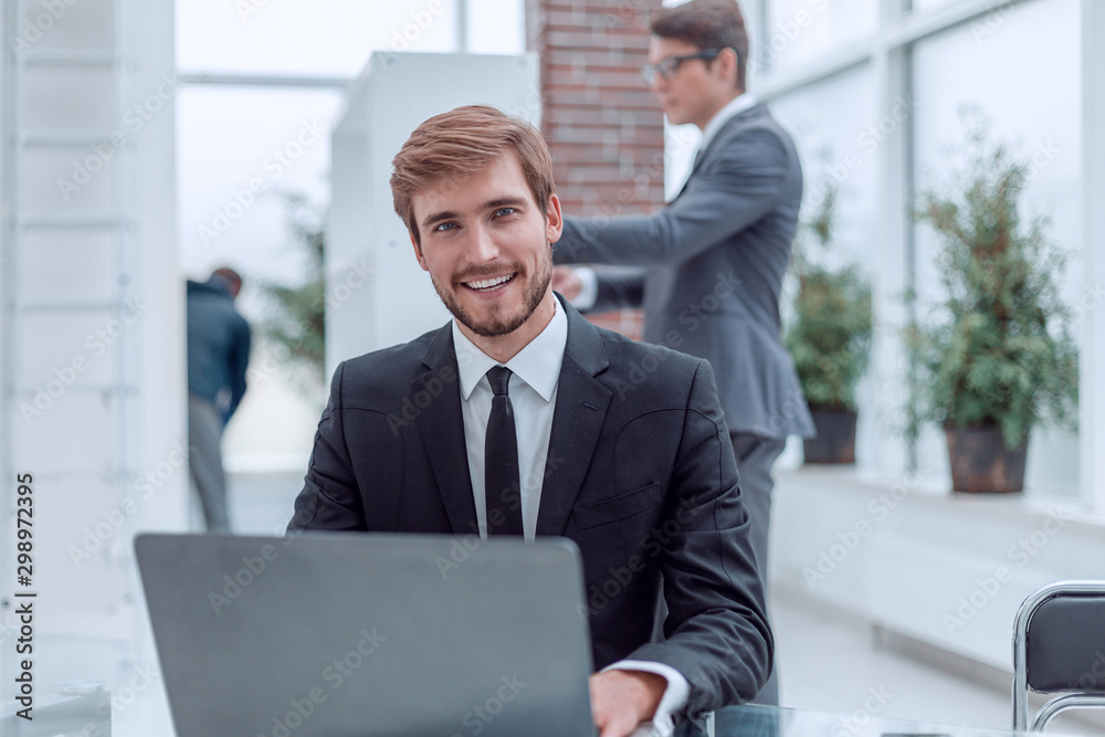 close up. smiling business men sitting at his Desk close up. smiling business men sitting at his Desk