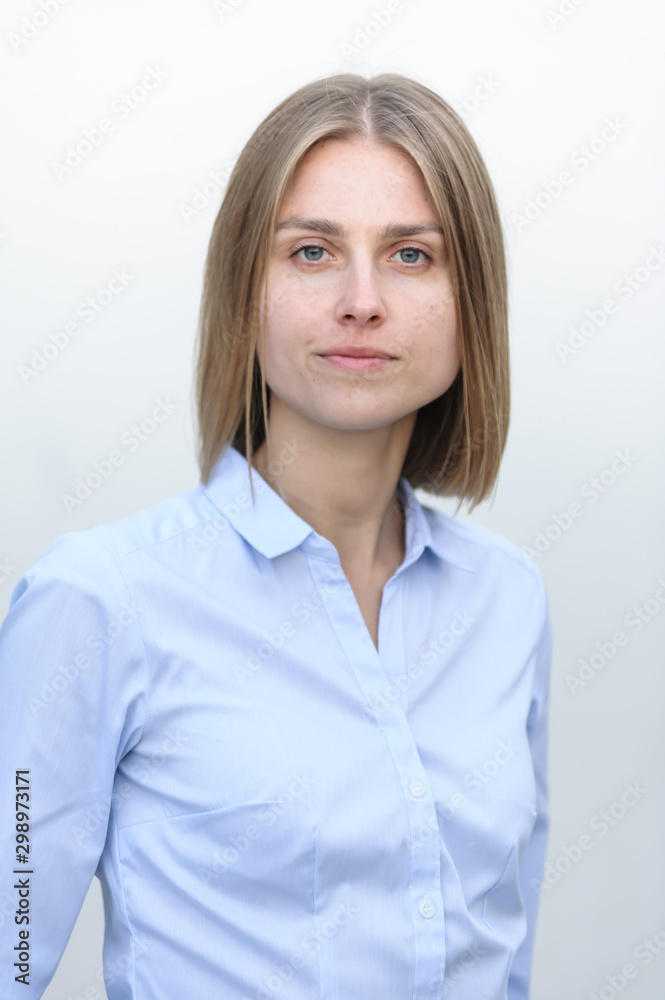 Blonde bussiness woman dressed casual with a perfect smile, standing near a white wall Blonde bussiness woman dressed casual with a perfect smile, standing near a white wall