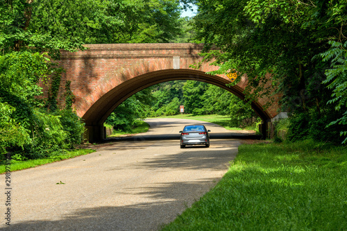 Colonial Parkway - A sunny Spring morning view of winding and scenic Colonial Parkway at one of its many brick bridges in Colonial National Historical Park, near Williamsburg, Virginia, USA. photo