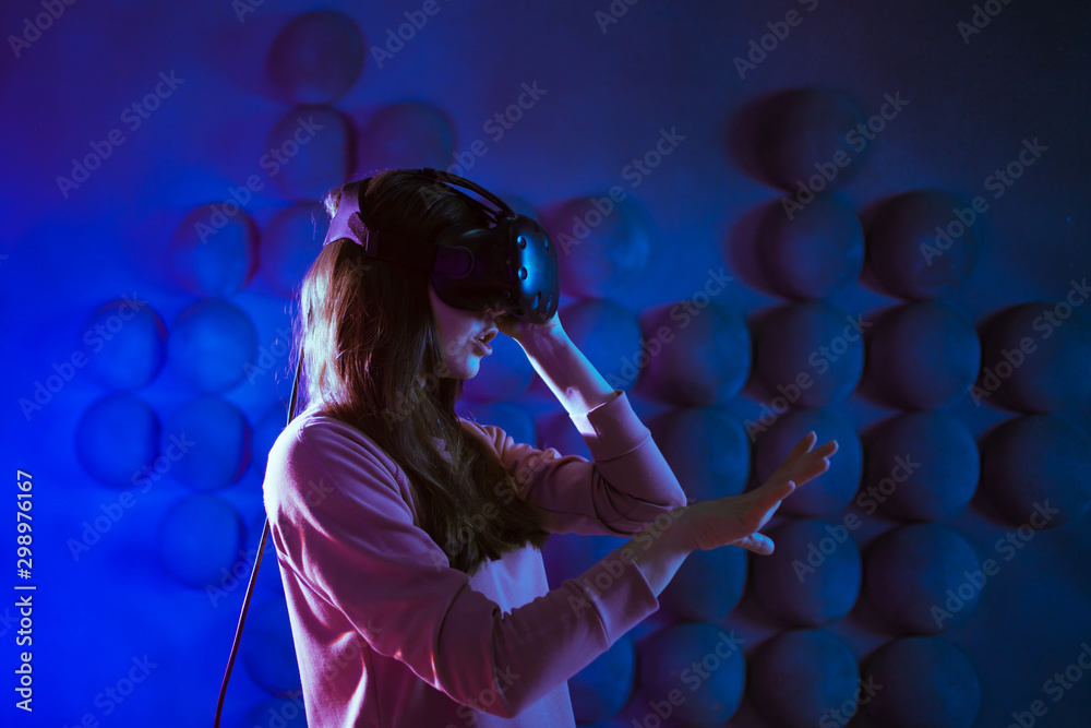 Ready for the game. The young woman in anticipation puts on VR glasses, gets ready for the game, touches the air. Ready for the game. The young woman in anticipation puts on VR glasses, gets ready for the game, touches the air.