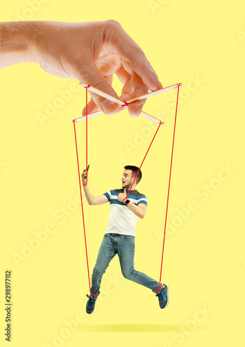 Canvastavla Man like a puppet in somebodies hands on yellow background