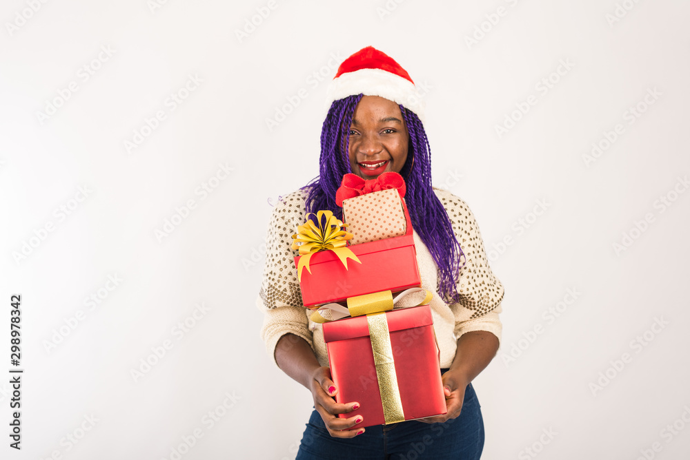 A dark-skinned happy girl holds a lot of red gifts in her hands. The concept of new Year, Christmas gifts, giving, Christmas shopping. Template for your advertising A dark-skinned happy girl holds a lot of red gifts in her hands. The concept of new Year, Christmas gifts, giving, Christmas shopping. Template for your advertising